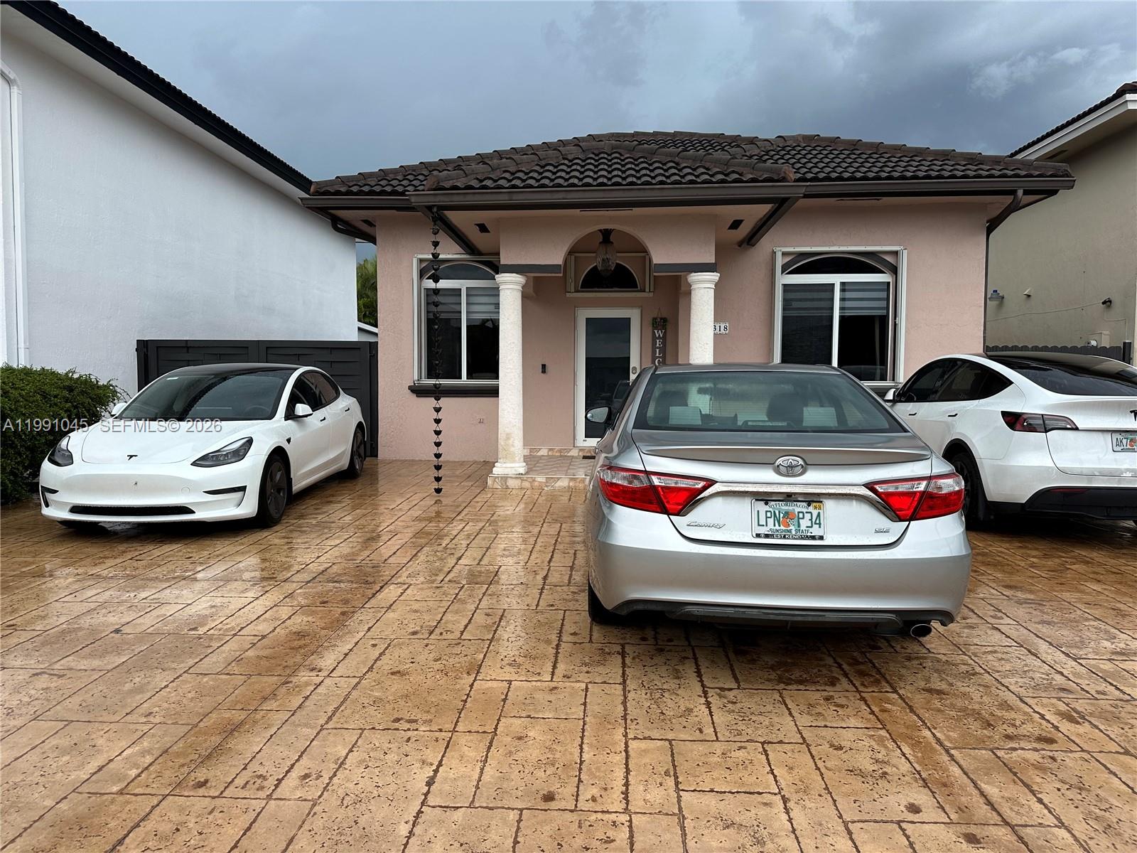 15318 Southwest 41st Terrace Miami, FL 33185 - Photo 2 of 30 a car parked in front of a house