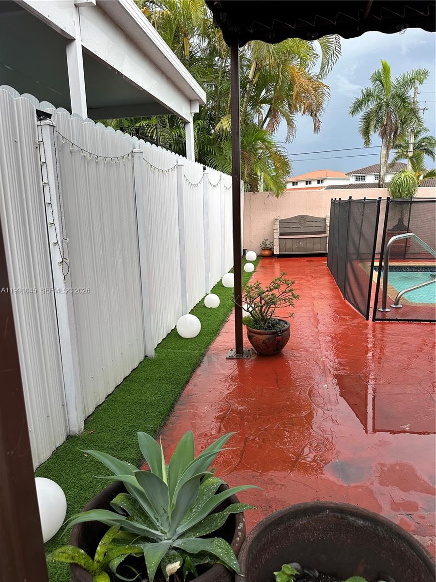 15318 Southwest 41st Terrace Miami, FL 33185 - Photo 29 of 30 a backyard of a house with table and chairs potted plants