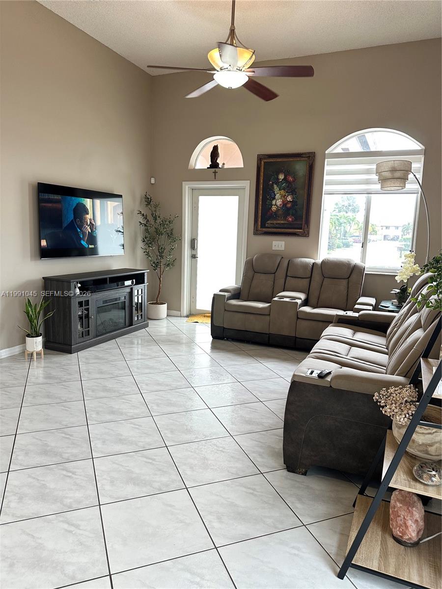 15318 Southwest 41st Terrace Miami, FL 33185 - Photo 5 of 30 a living room with furniture a flat screen tv and a fireplace
