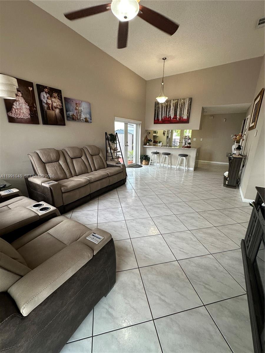 15318 Southwest 41st Terrace Miami, FL 33185 - Photo 6 of 30 a living room with furniture and a chandelier