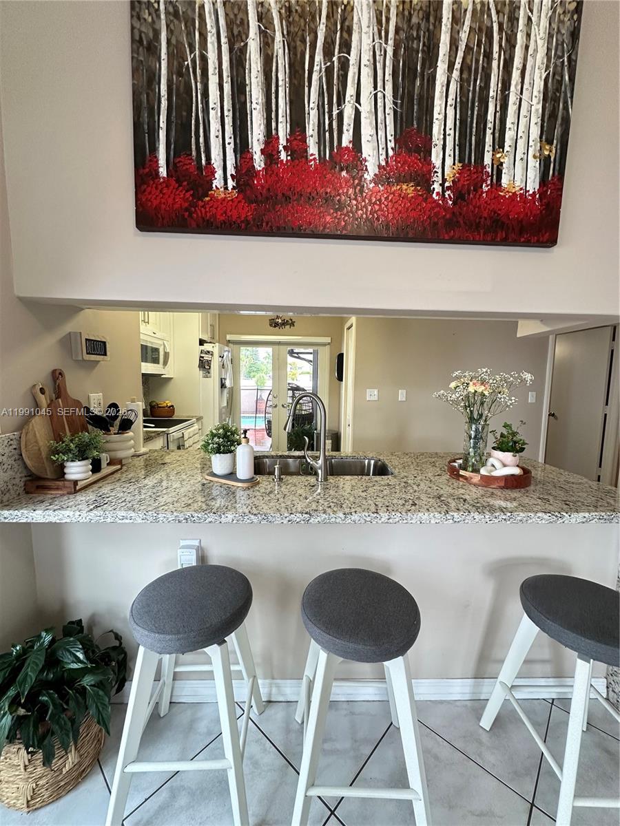15318 Southwest 41st Terrace Miami, FL 33185 - Photo 10 of 30 a kitchen with a dining table and chairs