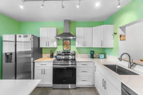 a kitchen with a stove a refrigerator and a sink