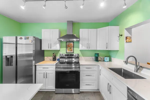 a kitchen with a stove a refrigerator and a sink