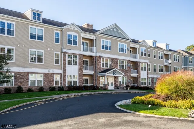 a front view of a residential apartment building with a yard