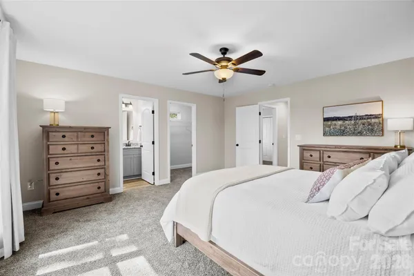 a spacious bedroom with a bed and a chandelier