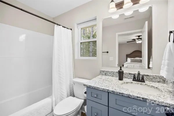 a bathroom with a granite countertop sink toilet and shower