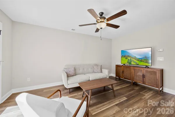 a living room with furniture and a wooden floor