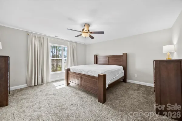 a bedroom with a bed and a ceiling fan
