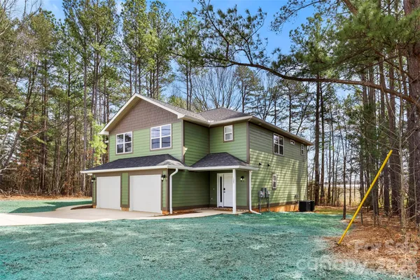 a front view of a house with a yard and trees