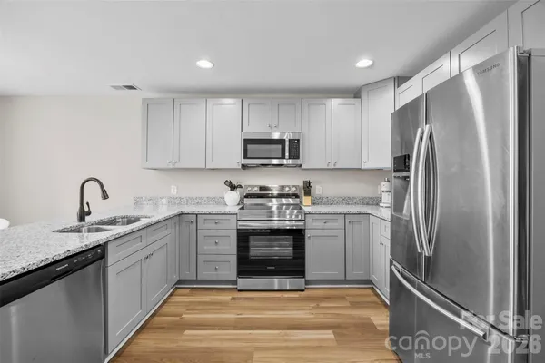 a kitchen with stainless steel appliances granite countertop a refrigerator sink and stove