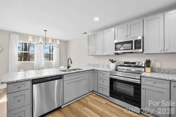 a kitchen with stainless steel appliances granite countertop a sink stove and microwave