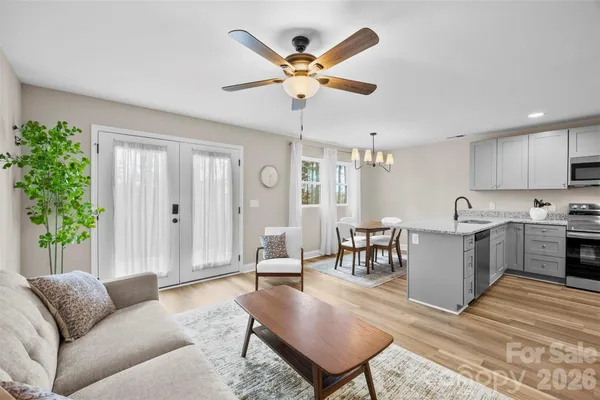a living room with furniture kitchen view and a window
