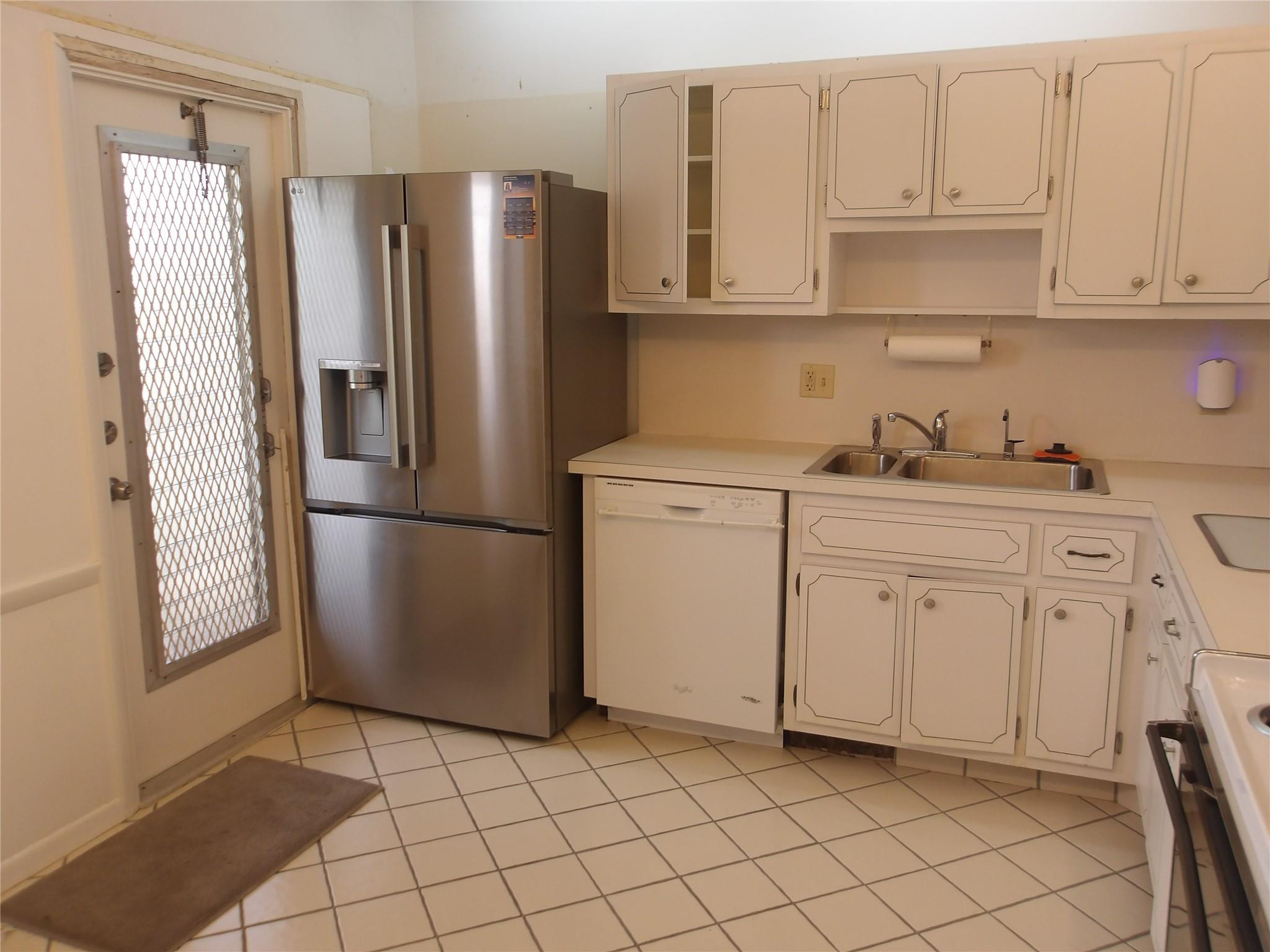 a kitchen with white cabinets and white appliances