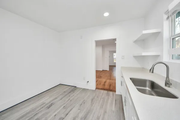 a kitchen with a sink cabinets and wooden floor