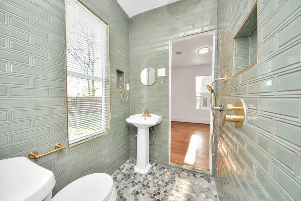 a bathroom with a sink a toilet and shower