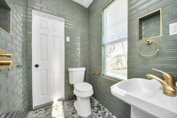 a bathroom with a sink a toilet and shower