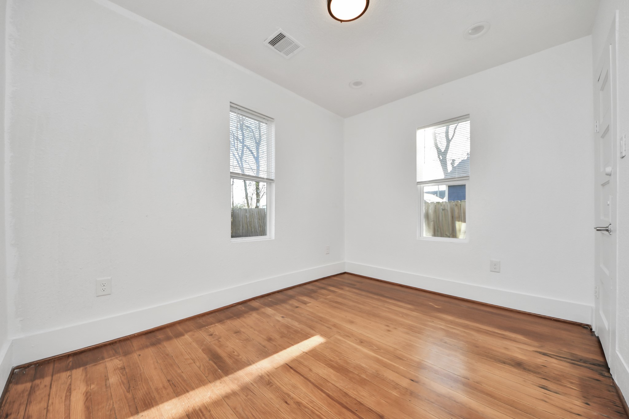 3423 Beulah Street Houston, TX 77004 - Photo 17 of 36 an empty room with wooden floor and windows