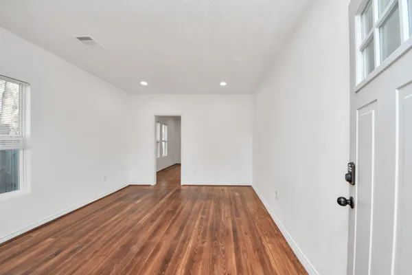 a view of a room with wooden floor and white walls