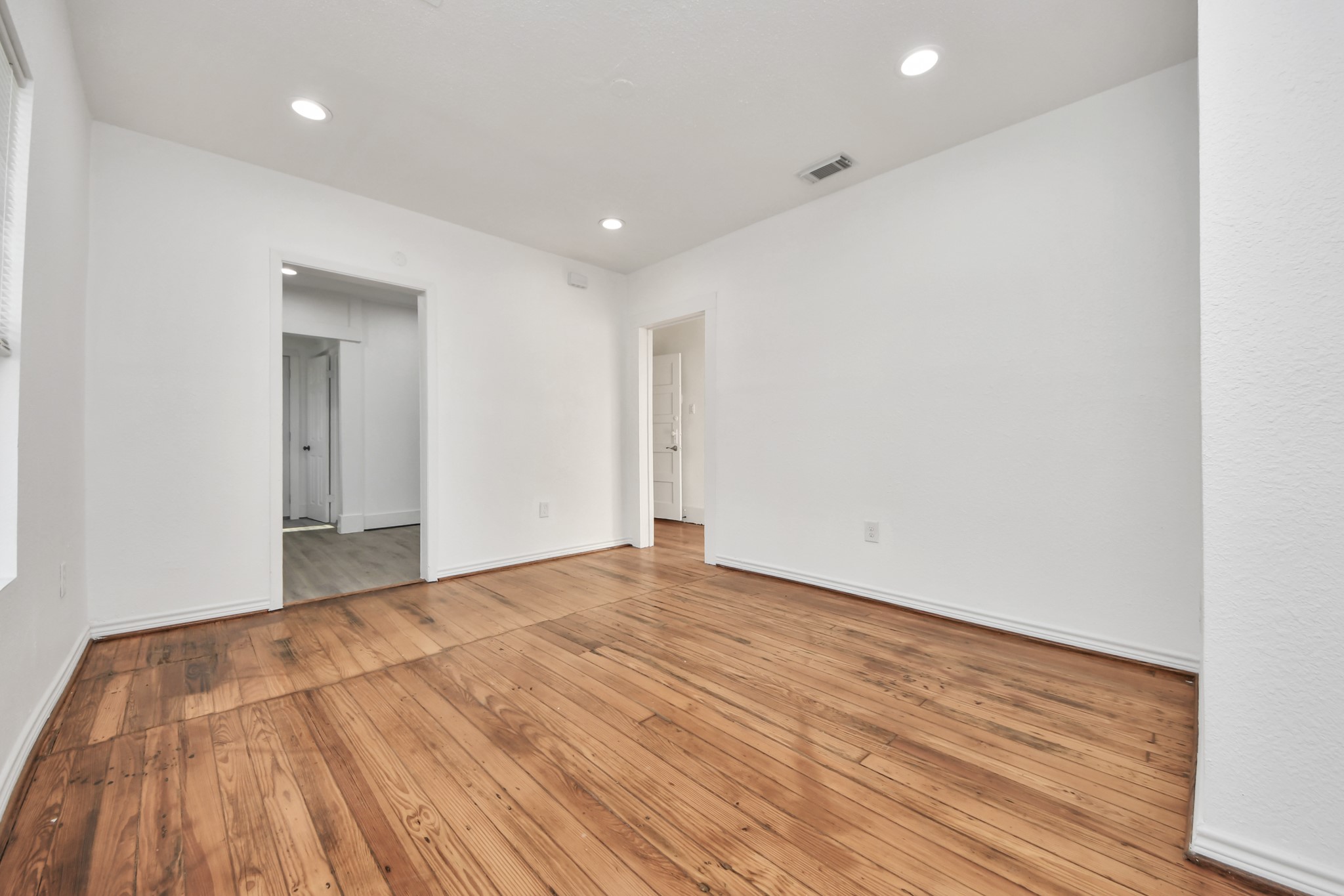3423 Beulah Street Houston, TX 77004 - Photo 9 of 36 a view of an empty room with wooden floor and a window