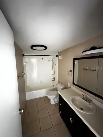 a spacious bathroom with a double vanity sink toilet mirror and bathtub