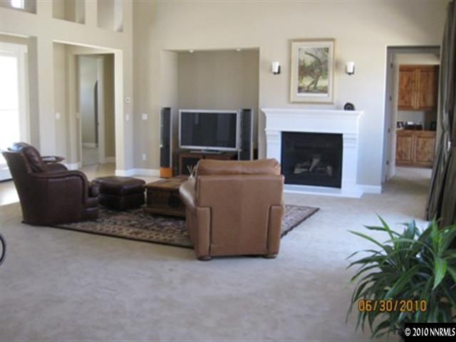 8549 Timaru Trail Reno, NV 89523 - Photo 3 of 9 a living room with furniture a flat screen tv and a fireplace
