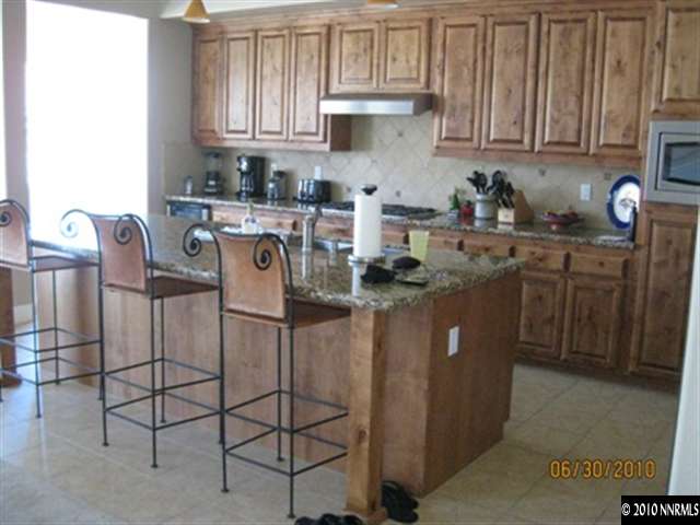 8549 Timaru Trail Reno, NV 89523 - Photo 4 of 9 a kitchen with stainless steel appliances granite countertop a sink a stove a refrigerator and cabinets