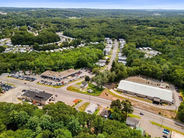 a view of a house with a yard and potted plants