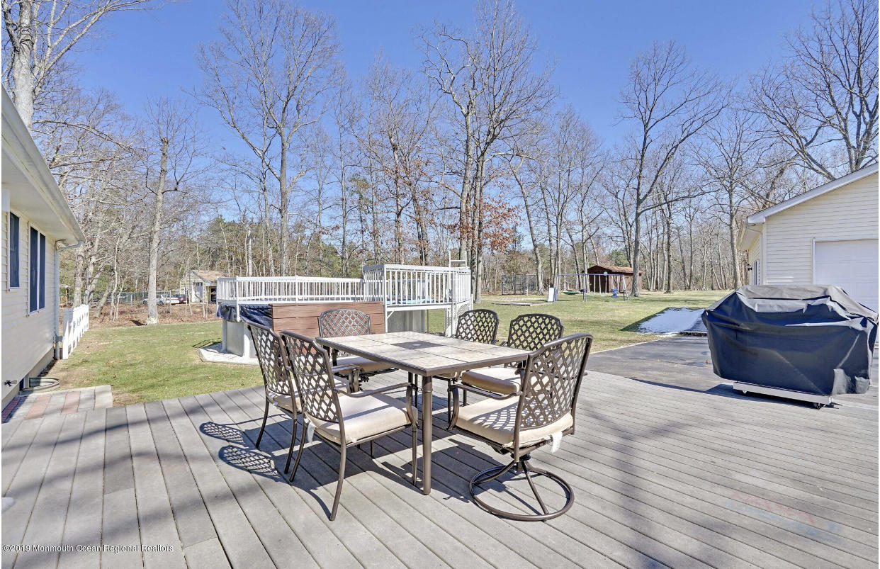 219 Jackson Pines Road Jackson, NJ 08527 - Photo 23 of 26 a view of a backyard with table and chairs and wooden floor