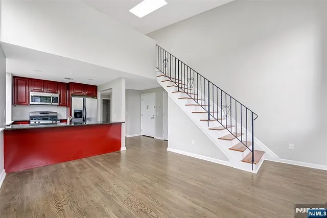 a view of staircase and kitchen with wooden floor