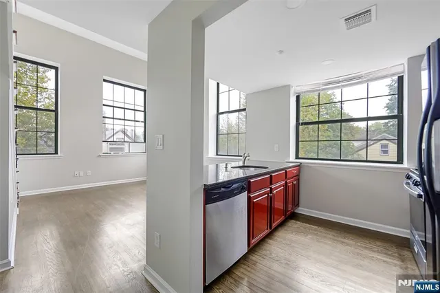 a large kitchen with stainless steel appliances granite countertop a stove and a large window