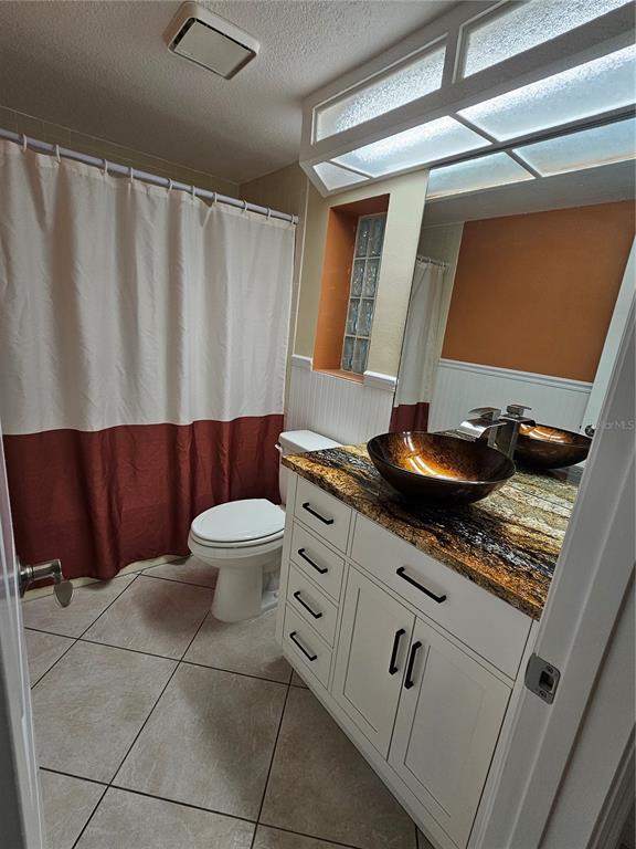 7313 Hatteras Drive Hudson, FL 34667 - Photo 23 of 33 a bathroom with a granite countertop sink and a toilet