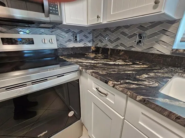 a stove top oven sitting inside of a kitchen