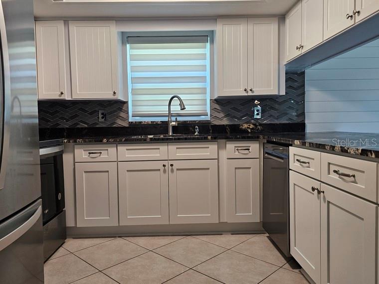 7313 Hatteras Drive Hudson, FL 34667 - Photo 6 of 33 a kitchen with white cabinets and sink