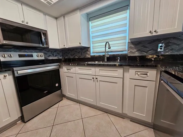 a kitchen with white cabinets and stainless steel appliances