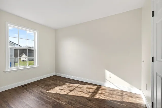a view of empty room with wooden floor