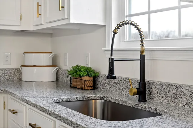 a kitchen with stainless steel appliances granite countertop a stove refrigerator sink and microwave