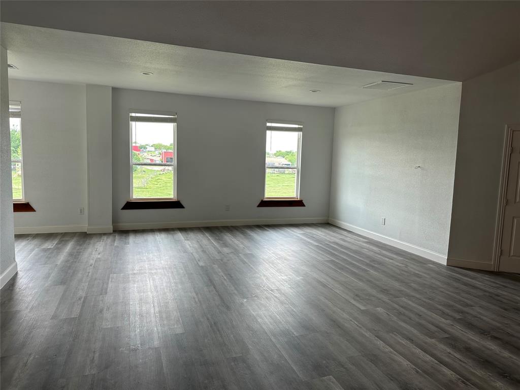 241 Gentry Road Ennis, TX 75119 - Photo 21 of 40 an empty room with wooden floor and windows