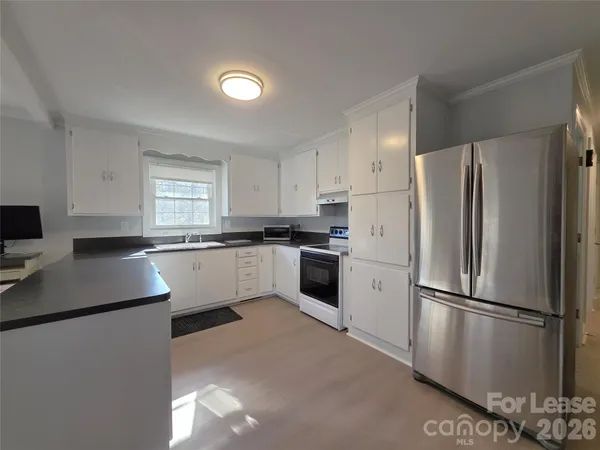 a kitchen with a refrigerator sink and cabinets