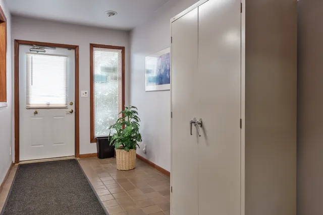 a view of a hallway with wooden floor and a potted plant