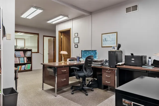 a view of a workspace with furniture and a bookshelf