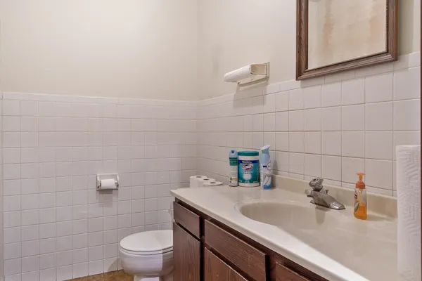 a bathroom with a sink a toilet and a mirror