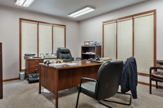 a view of a workspace with furniture and a window