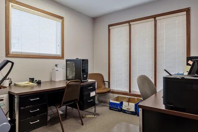 a view of a workspace with furniture and a window