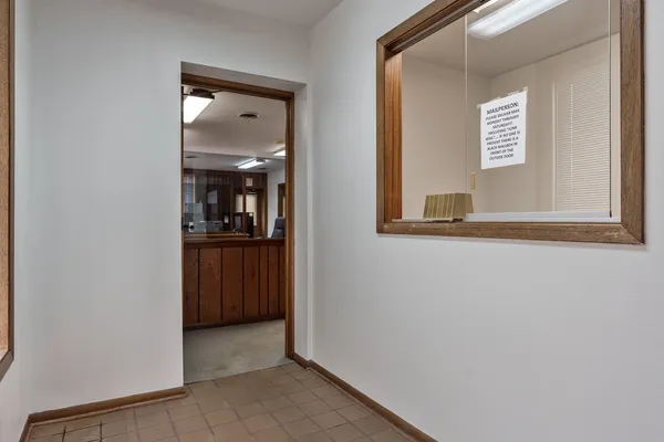 a view of a hallway with wooden floor and a living room