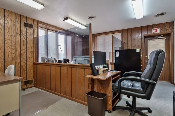 a view of a workspace with furniture and a window
