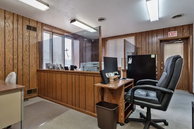 a view of a workspace with furniture and a window