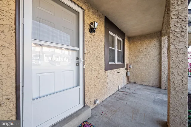 a view of an empty room with wooden floor a fireplace and a window