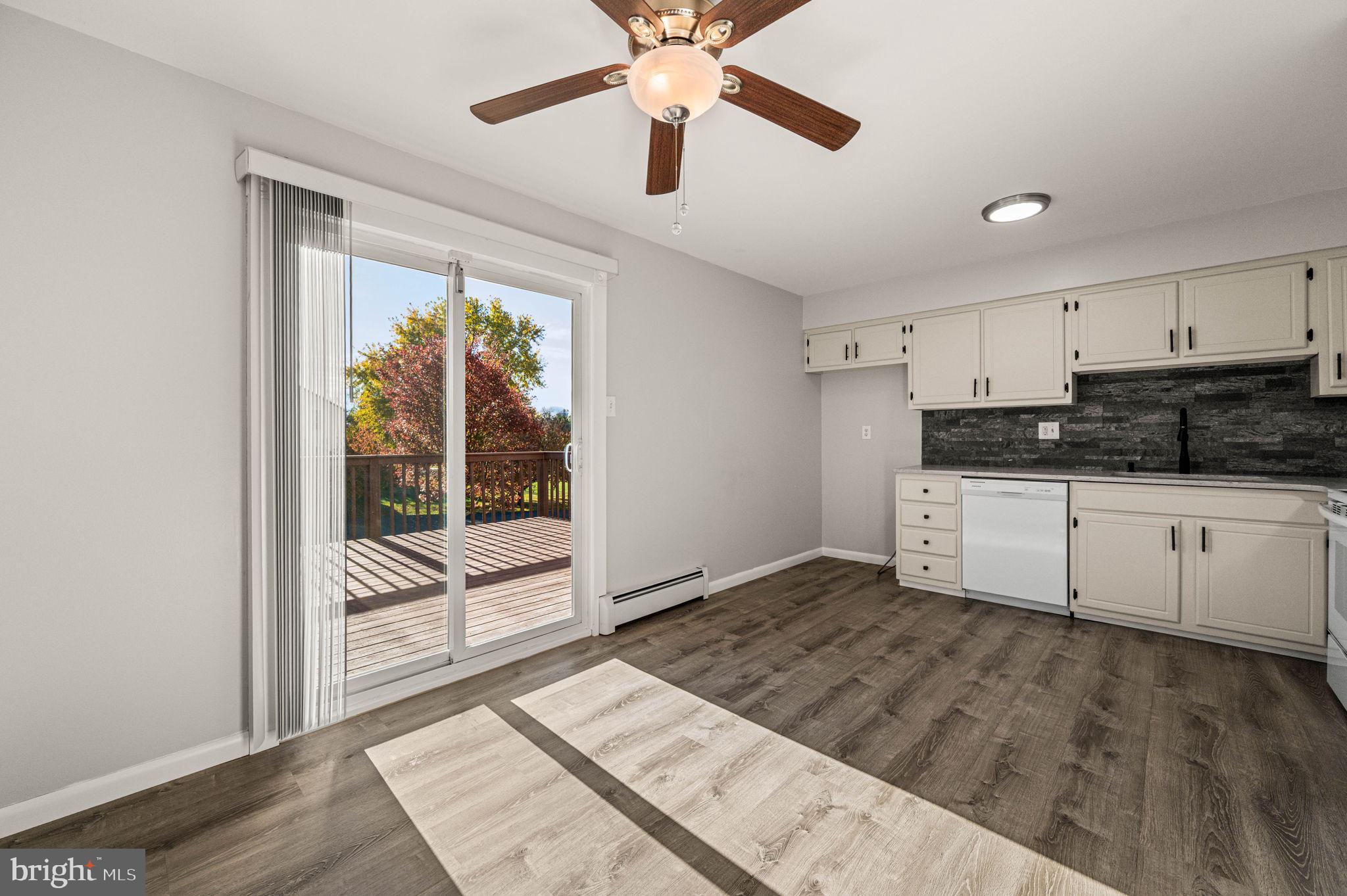 2404 Walnut Ridge Drive Pottstown, PA 19464 - Photo 8 of 24 a kitchen with granite countertop a stove a sink and white cabinets with wooden floor next to windows