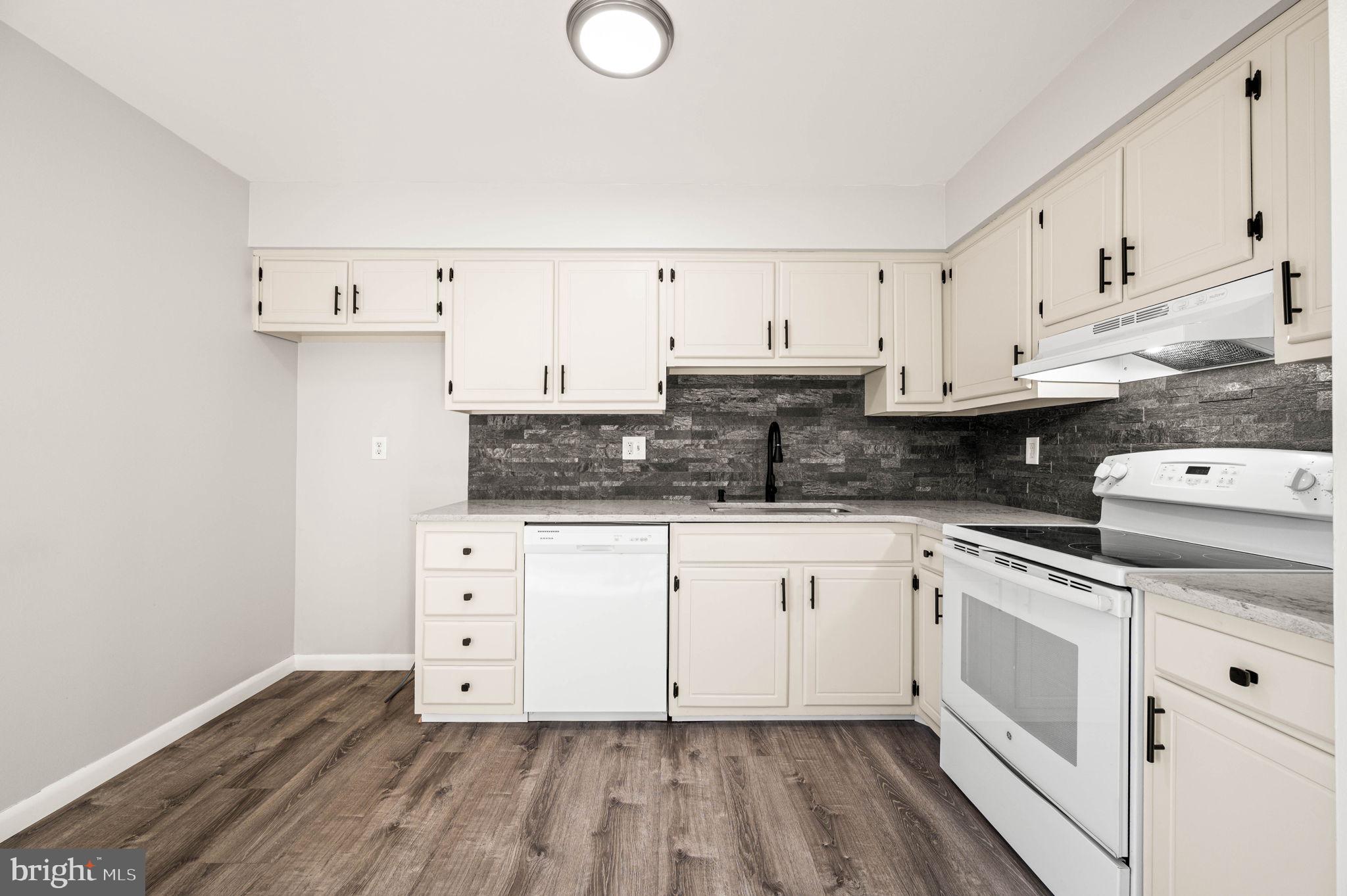 2404 Walnut Ridge Drive Pottstown, PA 19464 - Photo 9 of 24 a white kitchen with granite countertop white cabinets and white appliances