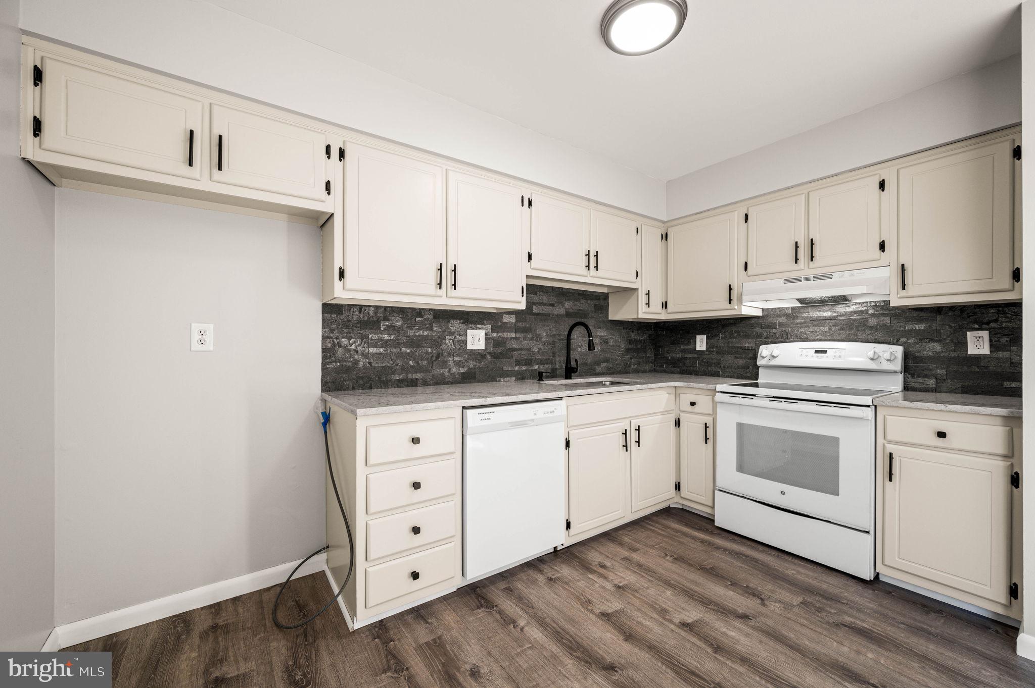 2404 Walnut Ridge Drive Pottstown, PA 19464 - Photo 10 of 24 a kitchen with cabinets stainless steel appliances a sink and wooden floor